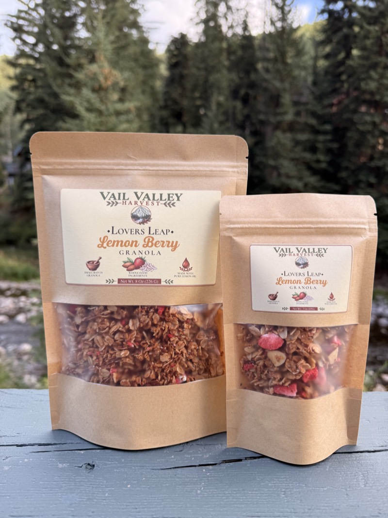 Lovers Leap Lemon Berry granola pouch in front of Vail pines